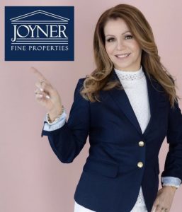 A professional woman with false lashes that perfectly complement her makeup look poses for the camera in a branding shot.