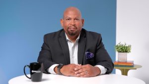 A professional man poses for the camera with confidence and radiant skin after a portrait session with Whole Life Beauty.
