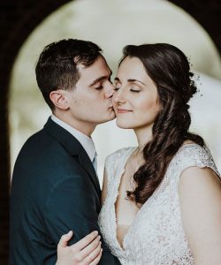 A young couple poses together for their wedding, the bride in light, natural makeup that lets her natural beauty shine through.