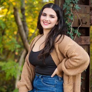 A young woman smiles for a camera, her natural beauty enhanced by clean makeup products expertly applied.