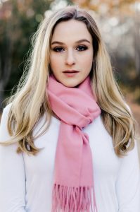 A young woman poses for the camera wearing a light touch of makeup chosen to match her skin tone, seasonal tones, and her style.