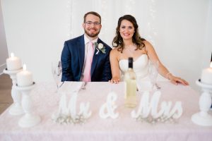 A young couple pose together in their wedding pictures, the bride showing off radiant skin complemented by quality beauty products. Whole Life Beauty uses only the best products to achieve the perfect look for any occasion!